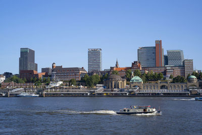 Scenic view of sea and buildings against clear sky