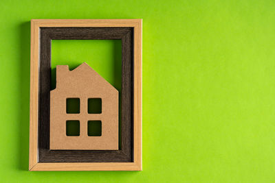 Close-up of mailbox on green wall against building