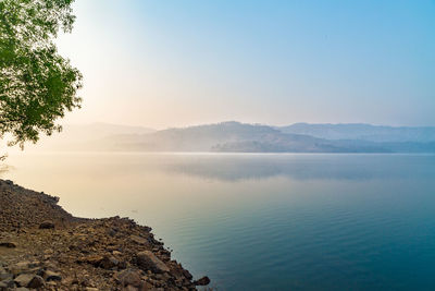 Scenic view of lake and mountains against clear sky