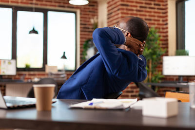 Side view of man working at table