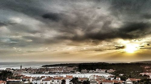 View of cityscape against cloudy sky