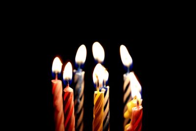 Close-up of burning candles in darkroom