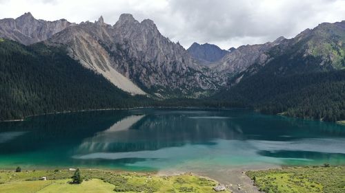 Scenic view of lake by mountains against sky