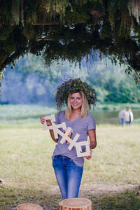 Portrait of a young woman standing on field