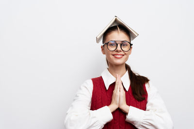 Portrait of young woman wearing sunglasses against white background