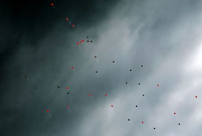 Low angle view of balloons flying against sky