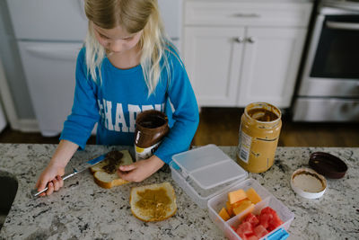 Little girl making a sandwich in the kitchen