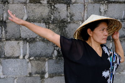 Mature woman wearing casuals while standing against wall