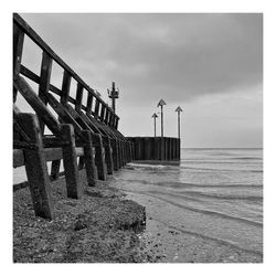 Wooden structure over sea against sky