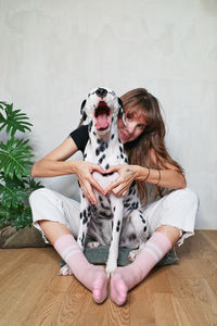 Woman with dog sitting on floor at home