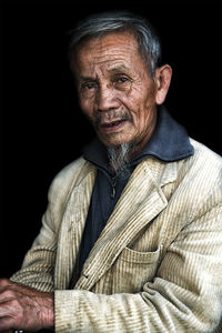 Portrait of smiling man against black background