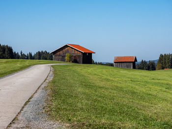 Houses on field against clear sky