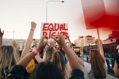 Rear view of women with banners marching for equal rights in city