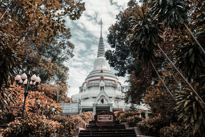 Low angle view of trees and building against sky