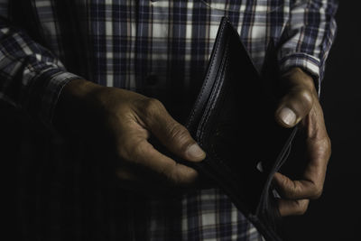 Midsection of man holding empty wallet