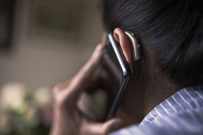 Woman with hearing aid talking via cell phone