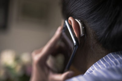 Close-up portrait of man holding mobile phone