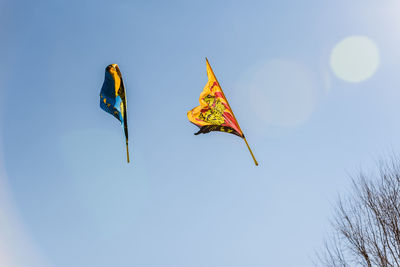 Low angle view of flag against clear blue sky