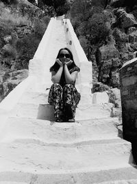 Full length of woman sitting on staircase