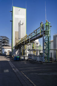 Engineers standing on bridge at recycling plant