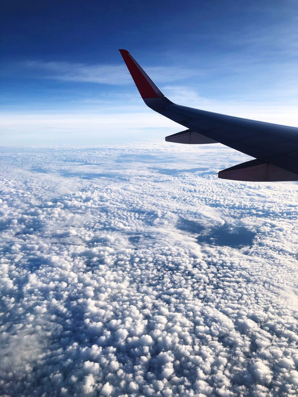 AIRPLANE FLYING OVER CLOUDS