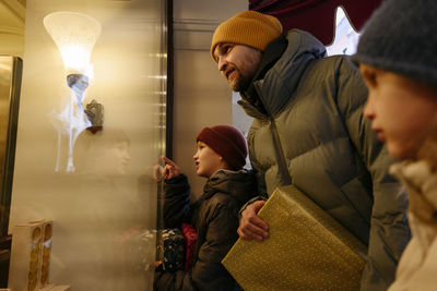 Father doing window shopping with children at store