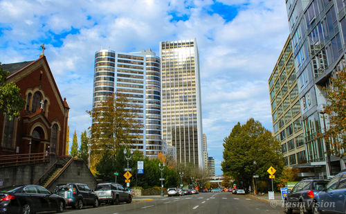 Cars on road amidst buildings against sky in city