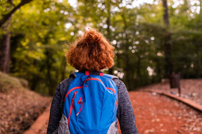 Rear view of woman standing against trees