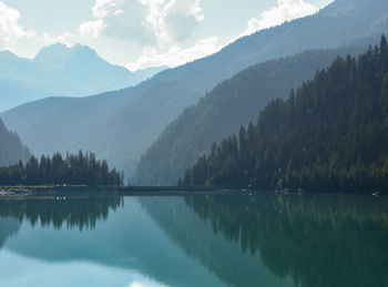 Scenic view of calm lake against cloudy sky