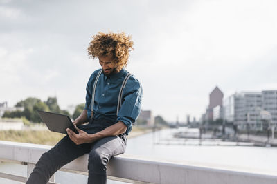 Young man using laptop outdoors