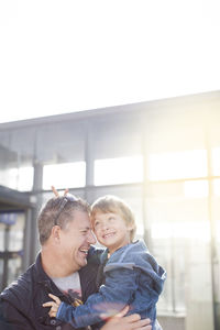 Smiling father with son outside building