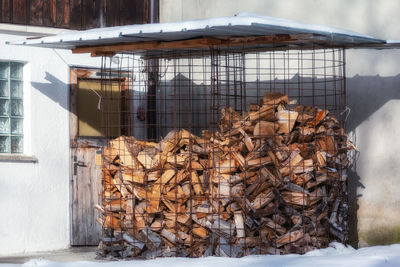 Close-up of stack of logs in snow