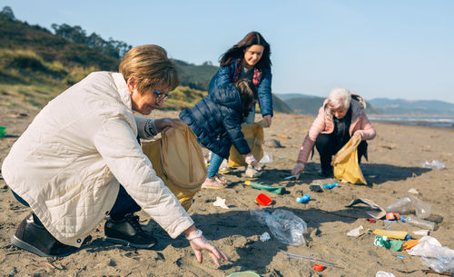 Family picking garbage at beach