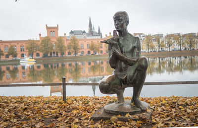 Statue of lake with buildings in background