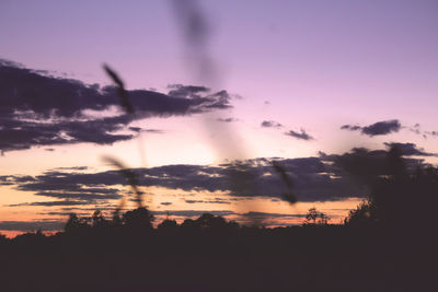 Silhouette landscape against dramatic sky during sunset