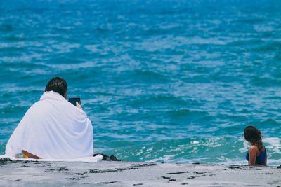 Rear view of woman sitting in water