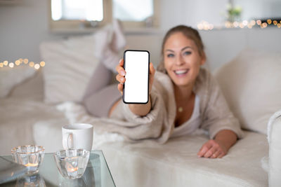 Young woman using mobile phone at home