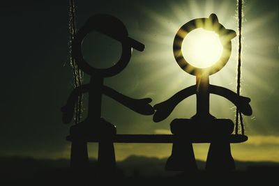 Low angle view of hanging light against sky during sunset