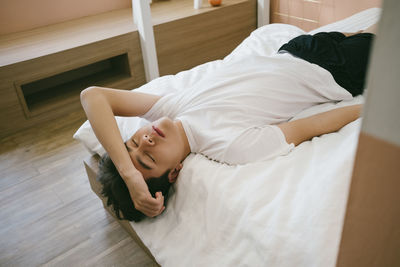 High angle view of woman lying on bed at home