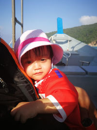 Portrait of cute baby girl wearing hat while sitting on boat