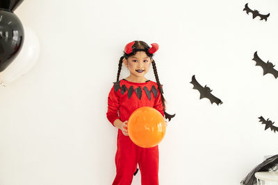 Full length of woman standing against red background