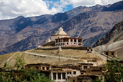Buildings against sky with mountain range in background