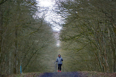 Full length rear view of man standing in forest