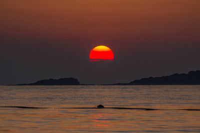 Scenic view of sea against orange sky
