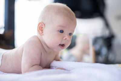 Close-up of cute baby boy lying on bed at home