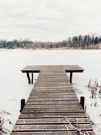 Pier over lake against sky during winter