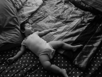 High angle view of child sleeping on bed at home