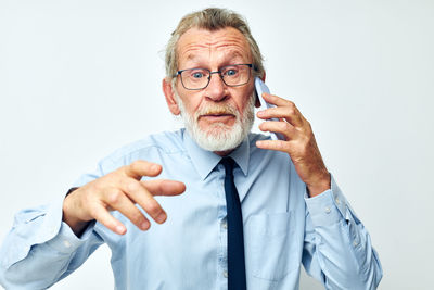 Senior man talking on phone against white background