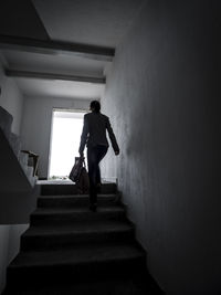 Rear view of woman walking on staircase of building