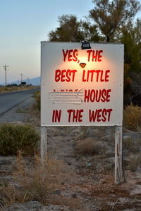 Close-up of warning sign against sky